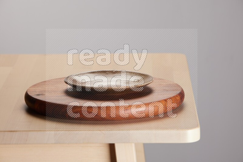 multi-colored pottery Plate placed on a dark colored wooden tray on the edge of wooden table