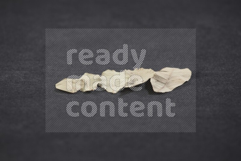 Dried bay leaves on black flooring