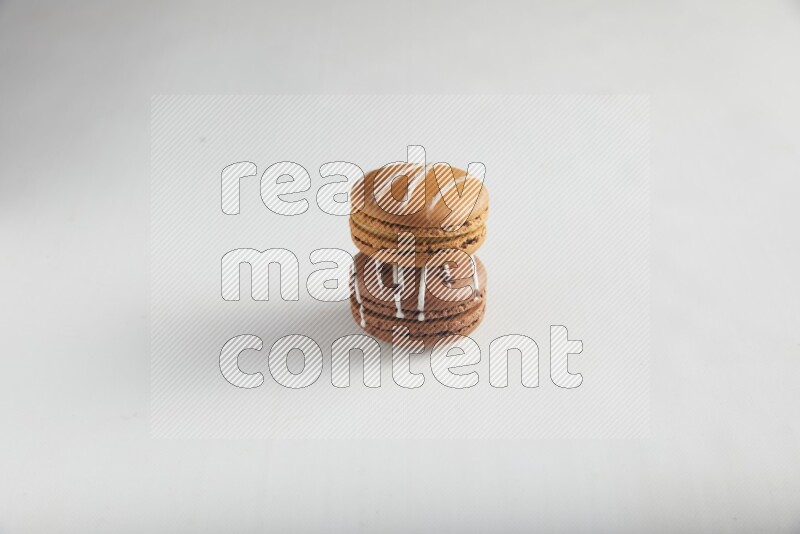 45º Shot of of two assorted Brown Irish Cream, and Brown white Chocolate Caramel macarons on white background