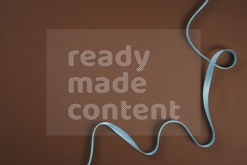 A blue collection of sewing and tailoring tools arranged on a brown background