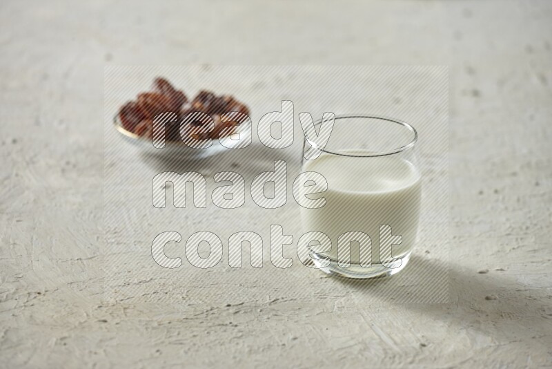 Cold drinks in a glass cup with dates such as water, tamarind, qamar eldin, sobia, milk and hibiscus on textured white background