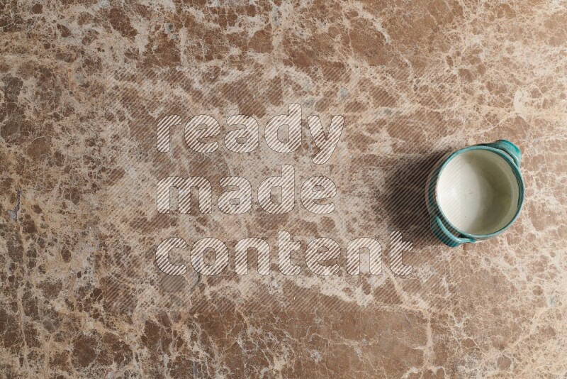 A multicolored pottery bowl on beige marble background