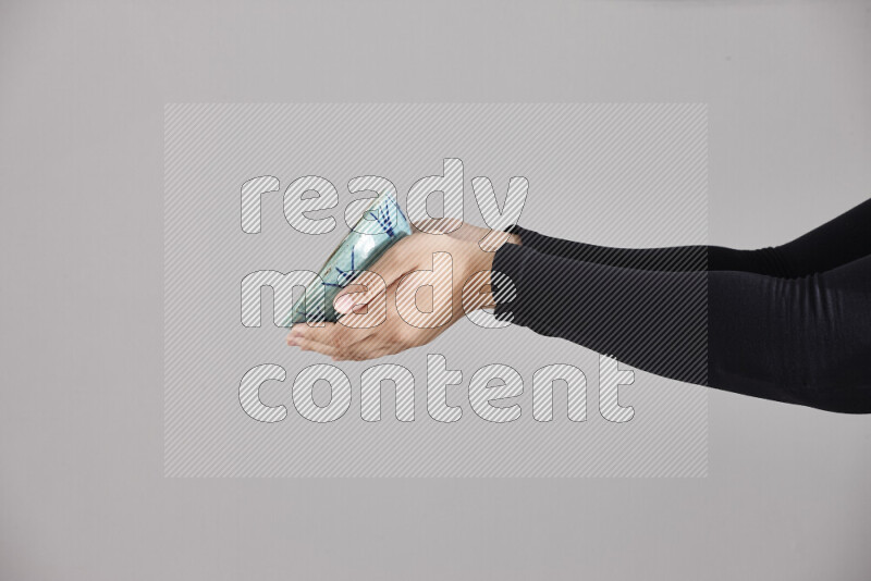 امرأة ترتدي عباءة سوداء تحمل أدوات فخارية مختلفة في أوضاع متعددة