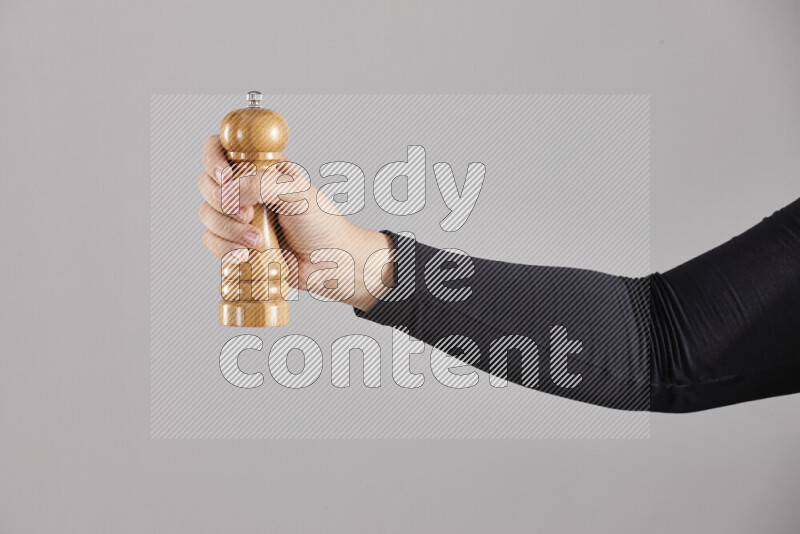 امرأة ترتدي عباءة سوداء تحمل أدوات خشبية مختلفة في أوضاع متعددة