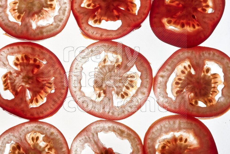 Tomatoes slices on illuminated white background