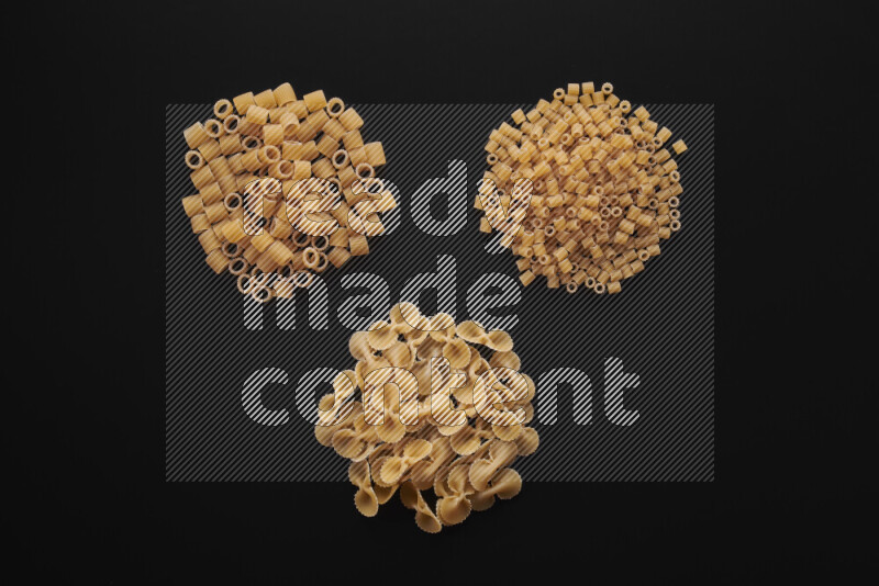 Different pasta types in bunches on black background