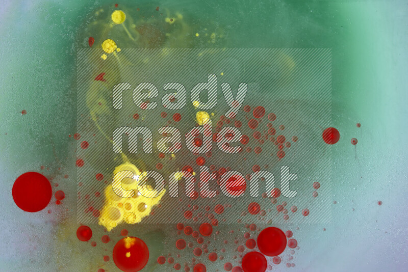 The image captures a dramatic splatter of red, green and yellow paints over the backdrop