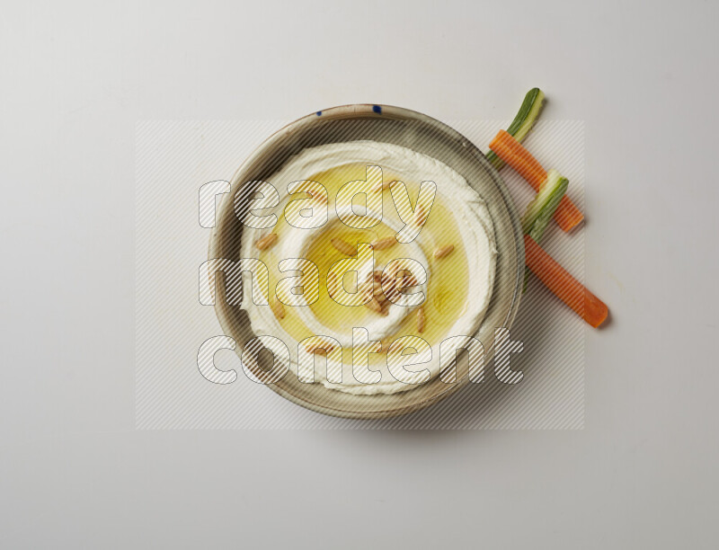 Lebnah garnished with pine nuts in a grey pottery plate on a white background
