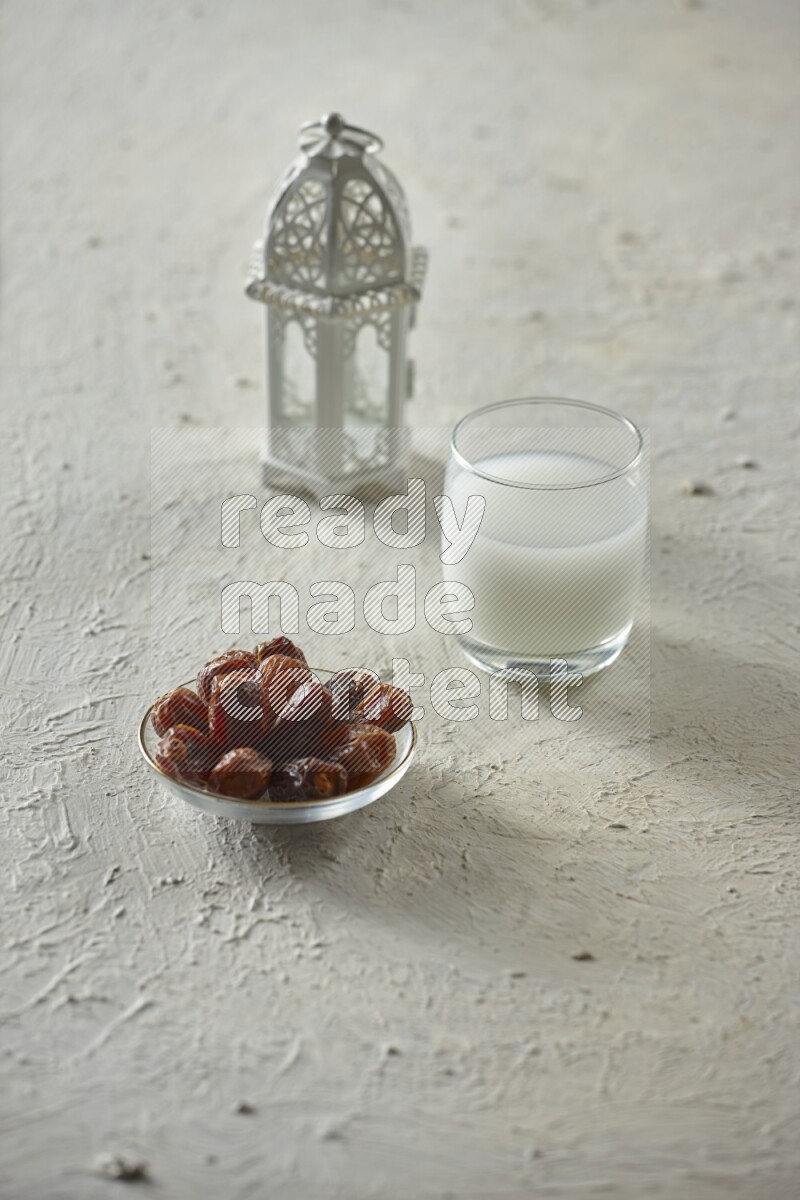 A white lantern with different drinks, dates, nuts, prayer beads and quran on white background