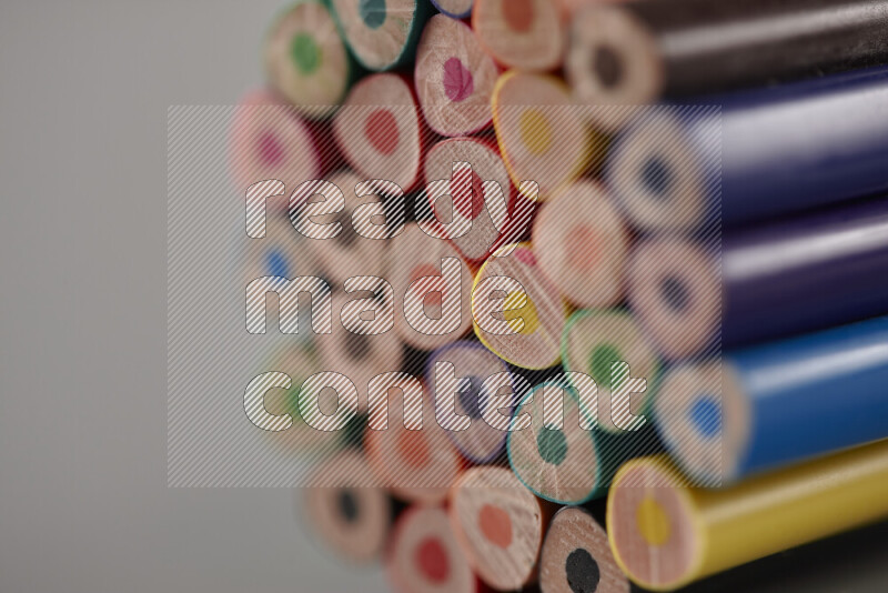An array of colored pencils on grey background