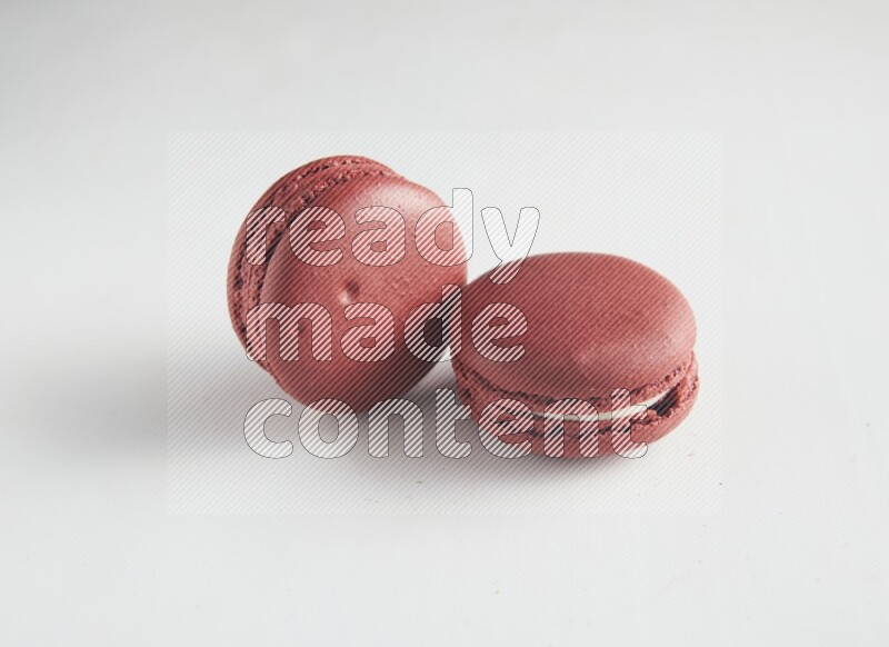 45º Shot of two Red Velvet macarons on white background