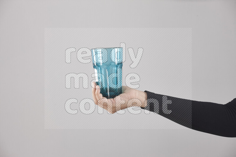 A woman in black abaya holding different glassware in different positions