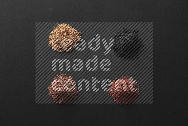 Black seeds, mustard seeds, garden cress and flax on a Black background