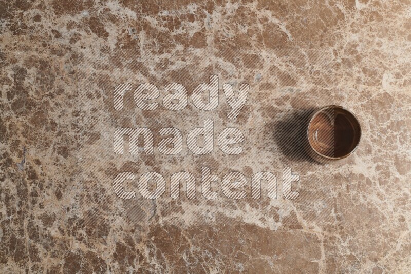 A pottery cup on beige marble background