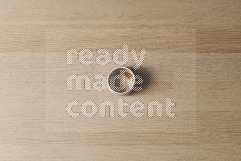 A multicolored pottery bowl on light wooden background