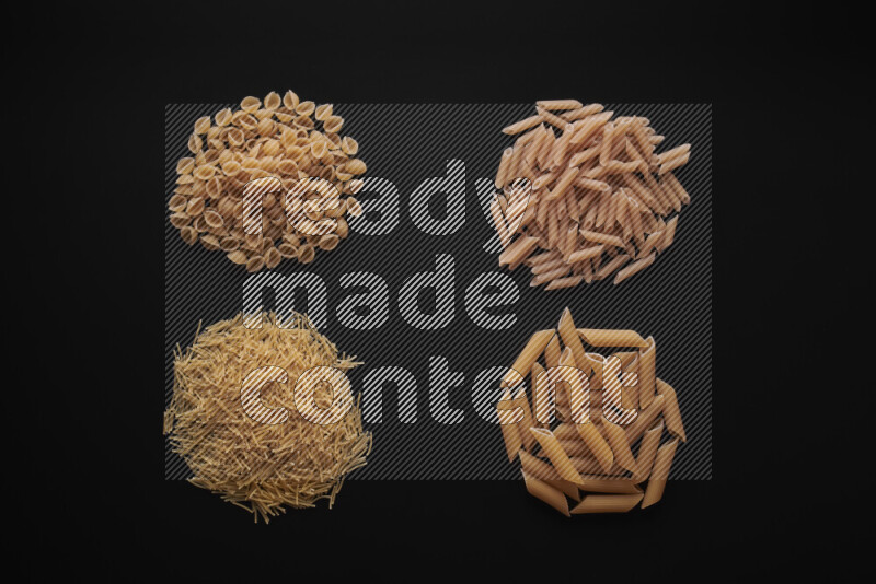 Different pasta types in bunches on black background