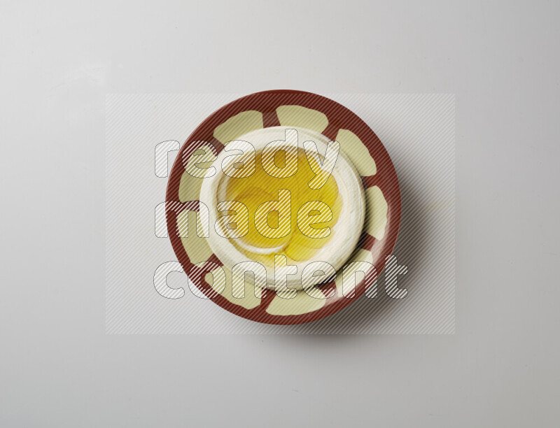 Lebnah garnished with olive oil in a traditional plate on a white background