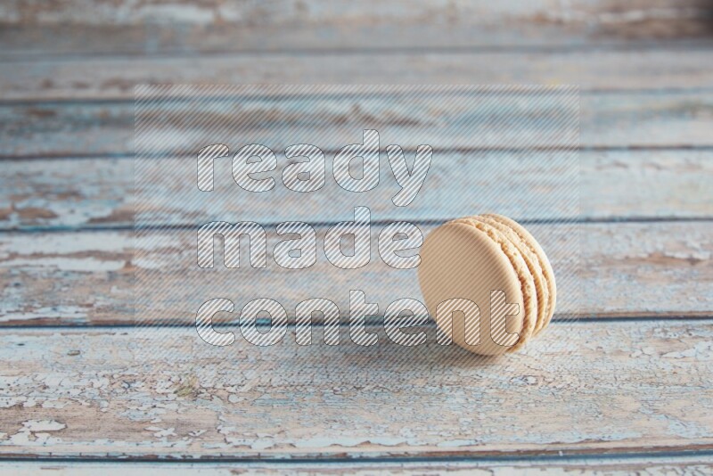 45º Shot of White Caramel fleur de sel macaron on light blue wooden background