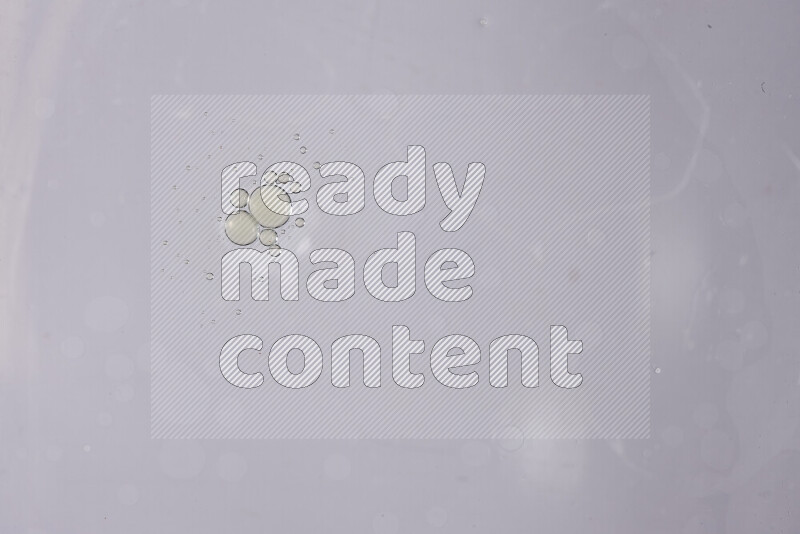 قطرات من الزيت على سطح الماء على خلفية بيضاء