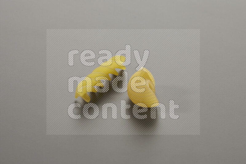 Pipe pasta with other types of pasta on grey background