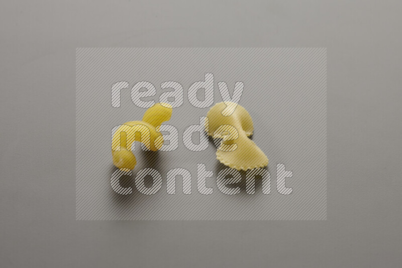 Twist pasta with other types of pasta on grey background