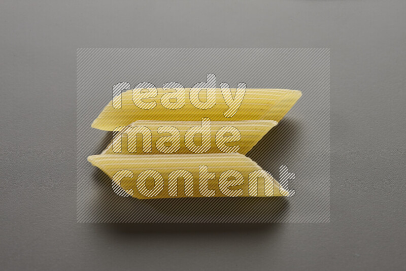 Penne pasta on grey background