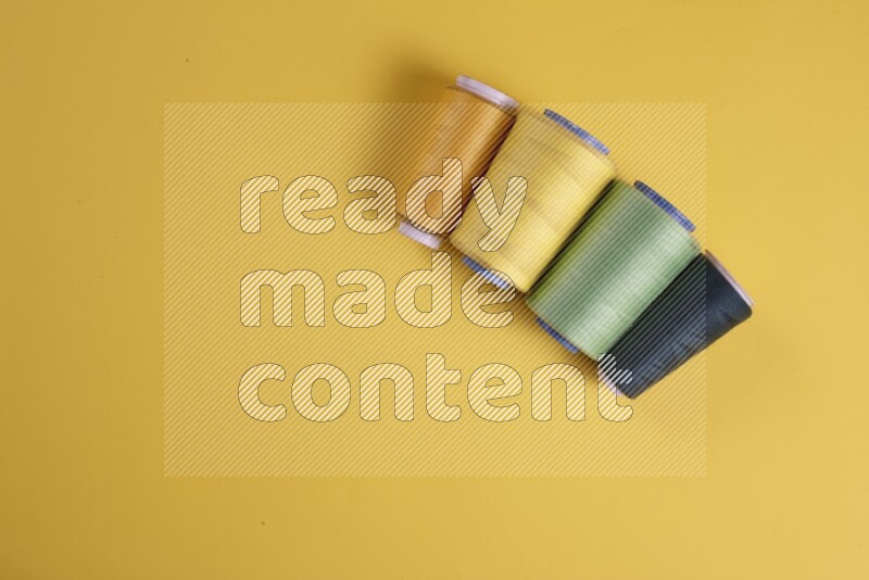 A green collection of sewing and tailoring tools arranged on a yellow background