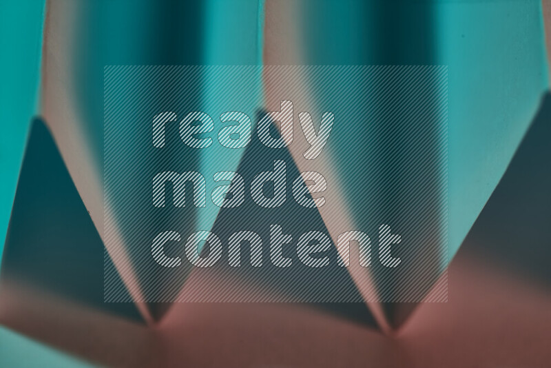 صورة مجردة مقربة تظهر طيات ورقية هندسية حادة بتدرجات اللون الأخضر والأحمر