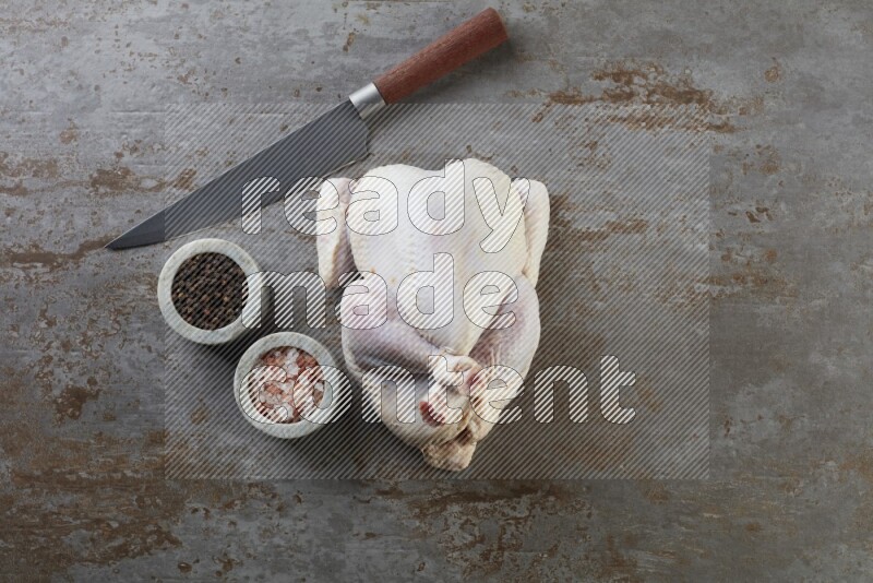 whole raw chicken  direct on a rustic grey background