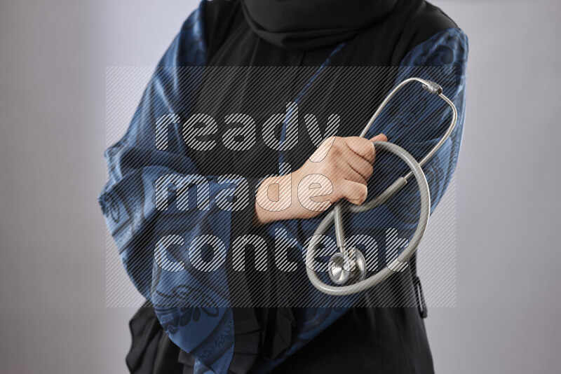 Female doctor wearing an abaya and medical attire in different positions