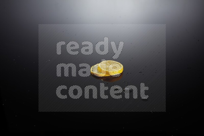 Lemon slices with water drops, and droplets on black background