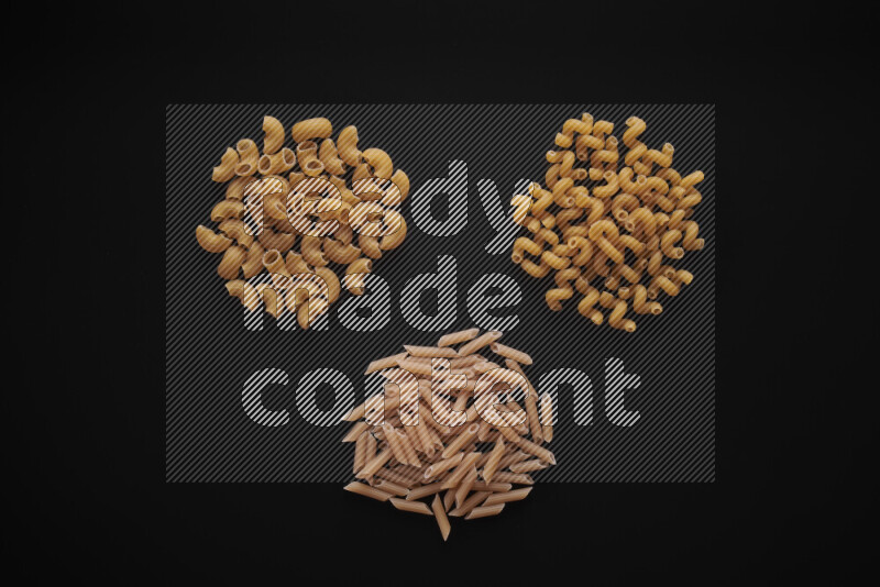 Different pasta types in bunches on black background