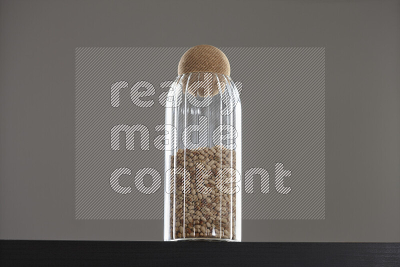 Black-eyed peas in a glass jar on black background