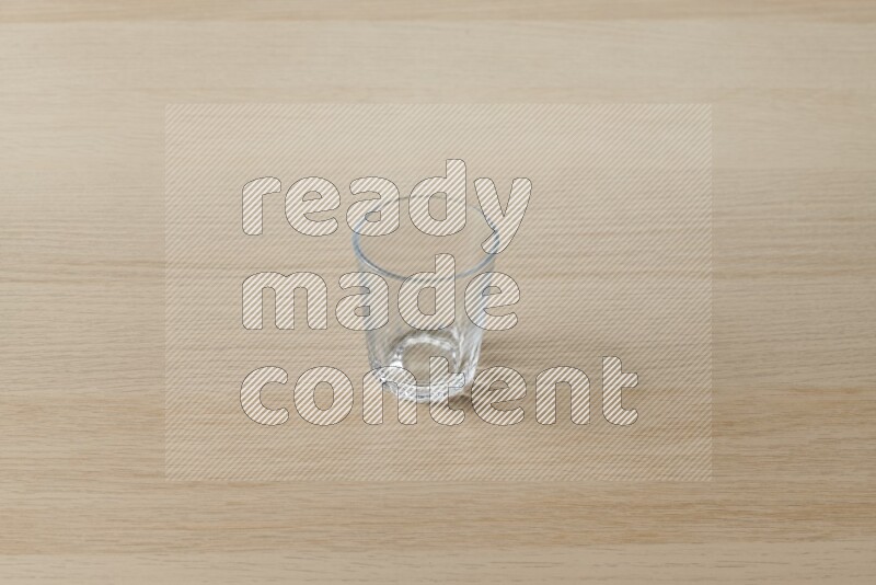 An empty glass cup on light wooden background