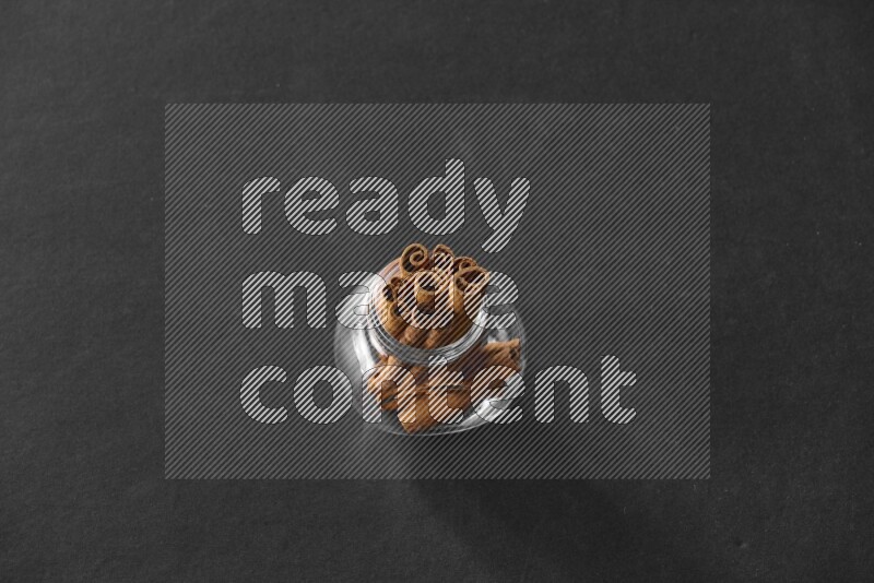 أعواد القرفة في وعاء زجاجي علي خلفية سوداء