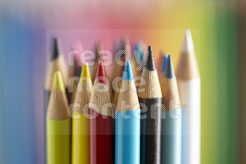 The image captures a close-up of sharpened colored pencils on multicolored background