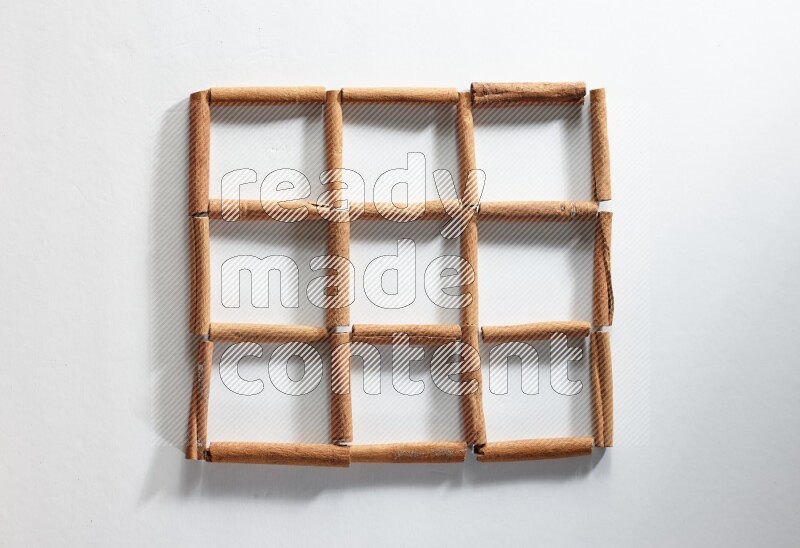 9 empty squares of cinnamon sticks on white flooring