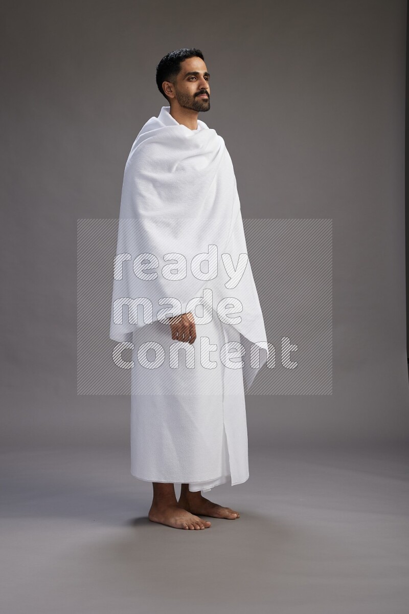 A man wearing Ehram Standing Interacting with the camera on gray background