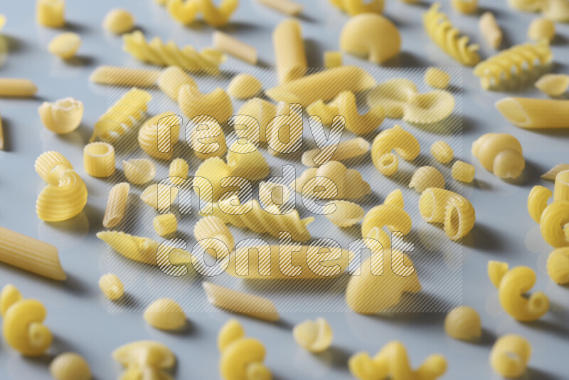 Different pasta types on light blue background