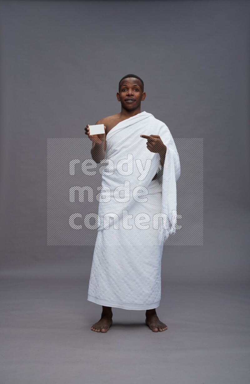 A man wearing Ehram Standing holding ATM card on gray background