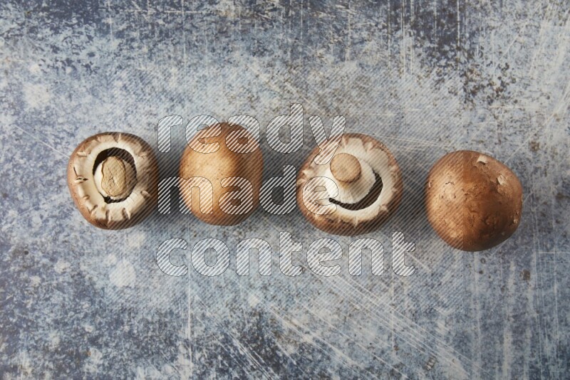 small fresh Cremini wood mushrooms topview on blue textured background