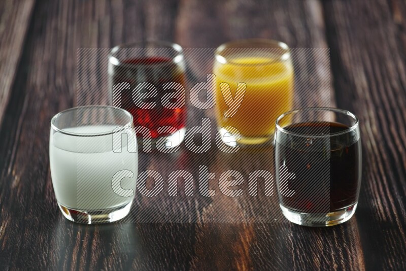 Cold drinks in a glass cup such as water, tamarind, qamar eldin, sobia, milk and hibiscus on wooden background