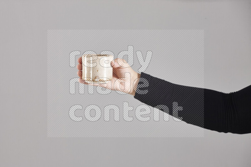 A woman in black abaya holding different pottery essentials in different positions