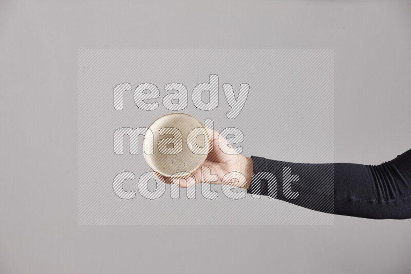 A woman in black abaya holding different pottery essentials in different positions