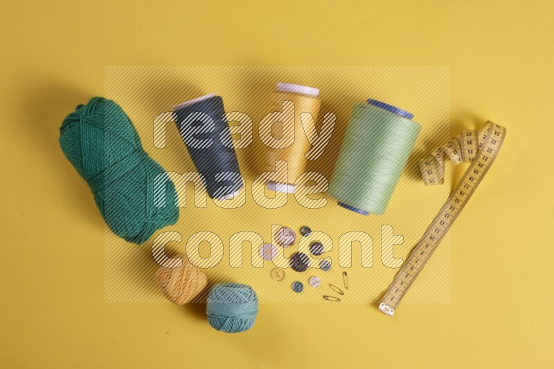 A green collection of sewing and tailoring tools arranged on a yellow background