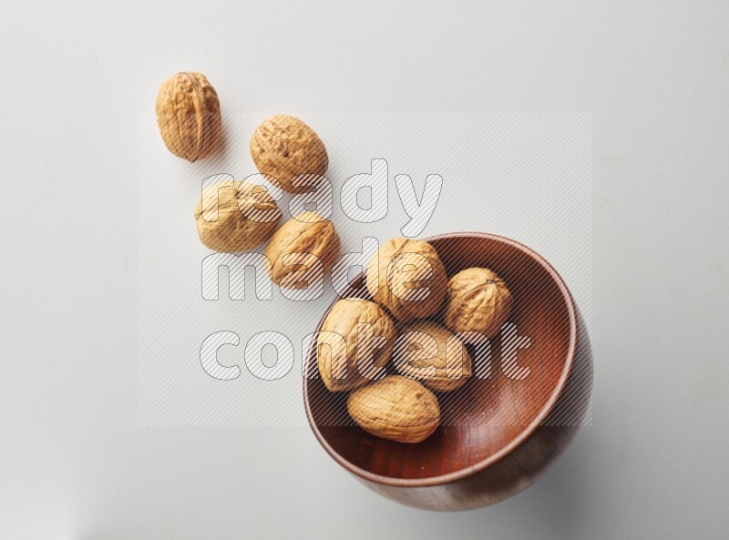 Top-view shot of walnut in a container on white background