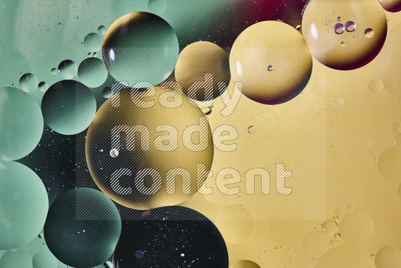 Close-ups of abstract oil bubbles on water surface in shades of yellow, red and green