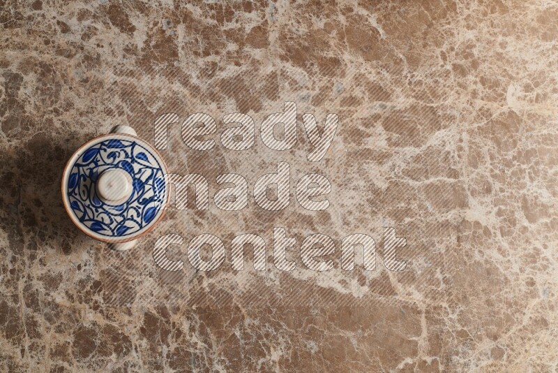 A multicolored pottery pot on beige marble background