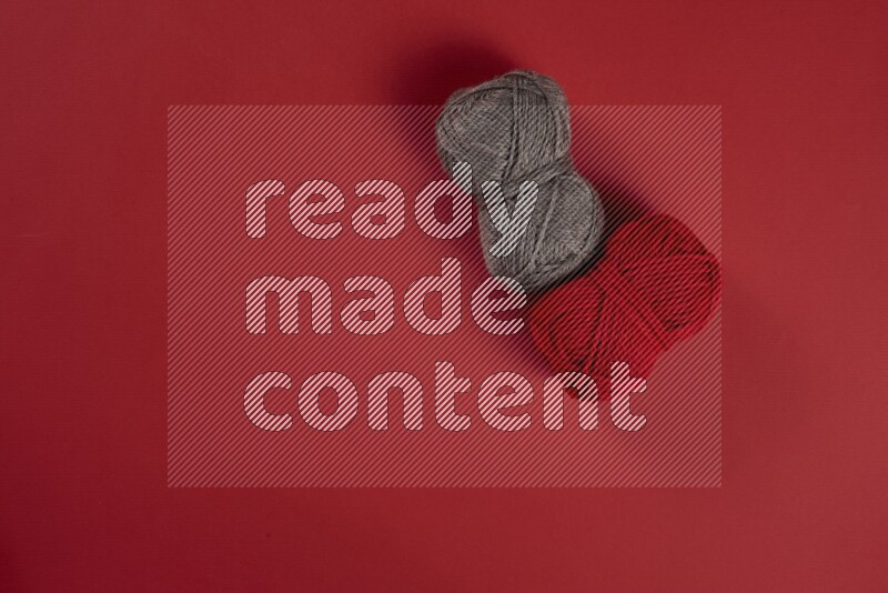 مجموعة من أدوات الخياطة والتفصيل بنية وحمراء اللون على خلفية حمراء