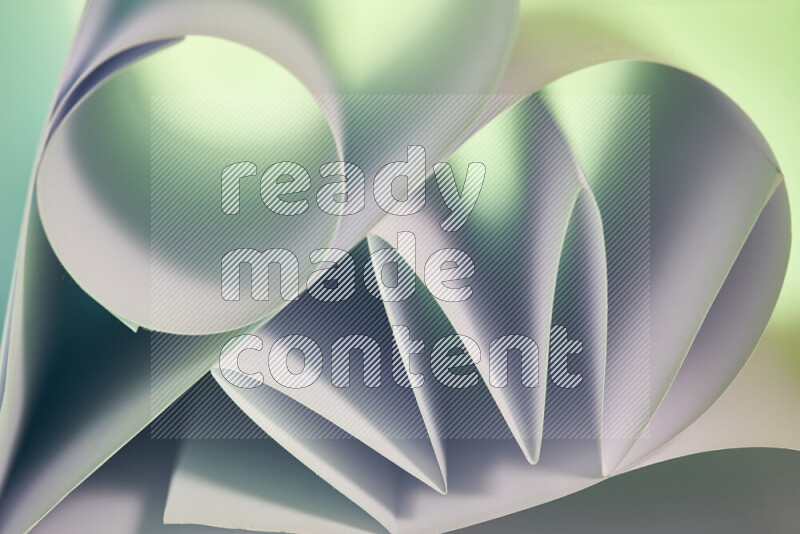 An artistic display of paper folds creating a harmonious blend of geometric shapes, highlighted by soft lighting in green and red tones